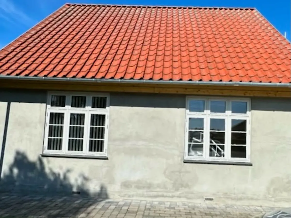 Husfacade med skjoldet, ubehandlet puds før malerarbejdet